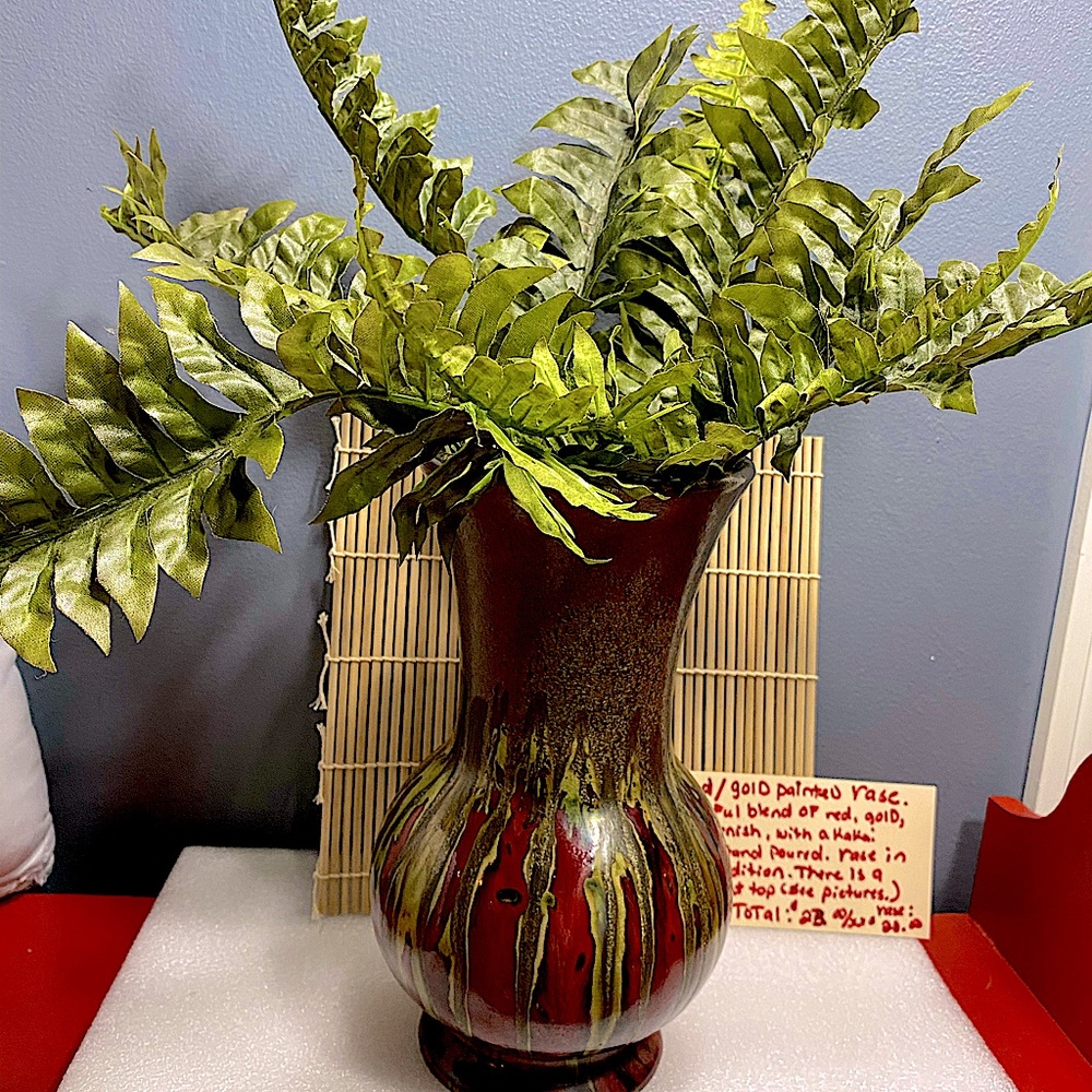 This is a beautiful red, vase with various colors of yellow and khaki running